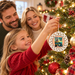 Parents and child decorating a Christmas tree with Meet Me at the Fishin’ Hole Ceramic Ornament