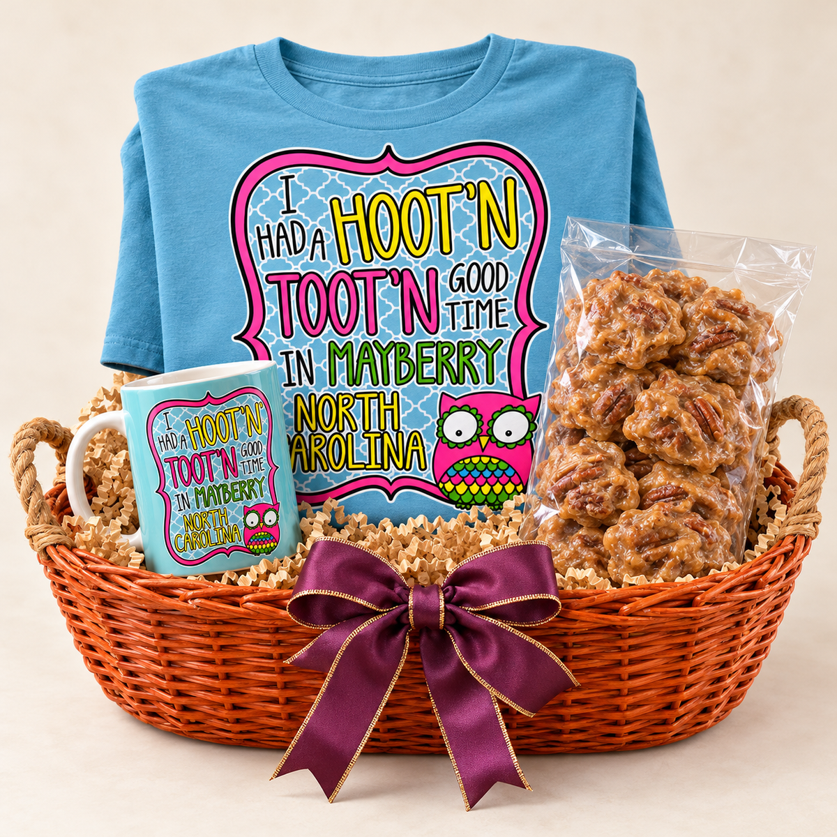 Hootin' Tootin' Harvest in a burnt orange canoe-shaped wicker basket with owl T-shirt, owl mug, and ten-count pralines — styled preview