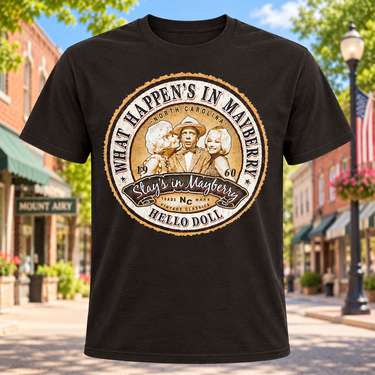 What Happens in Mayberry Stays in Mayberry T-Shirt in Dark Brown against a bright Mayberry Main Street background