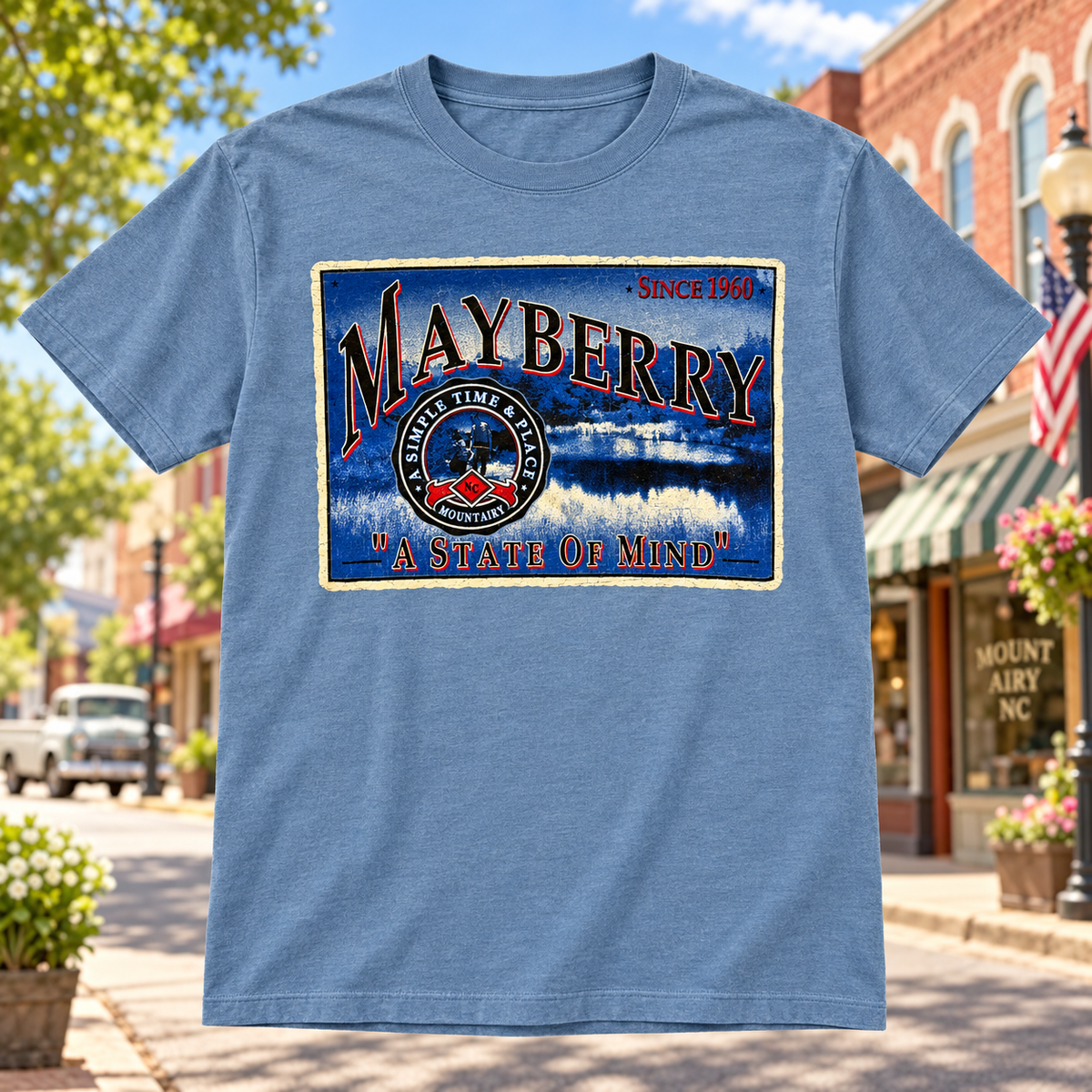 Mayberry State of Mind T-Shirt in Heather Blue against a bright Mayberry Main Street background