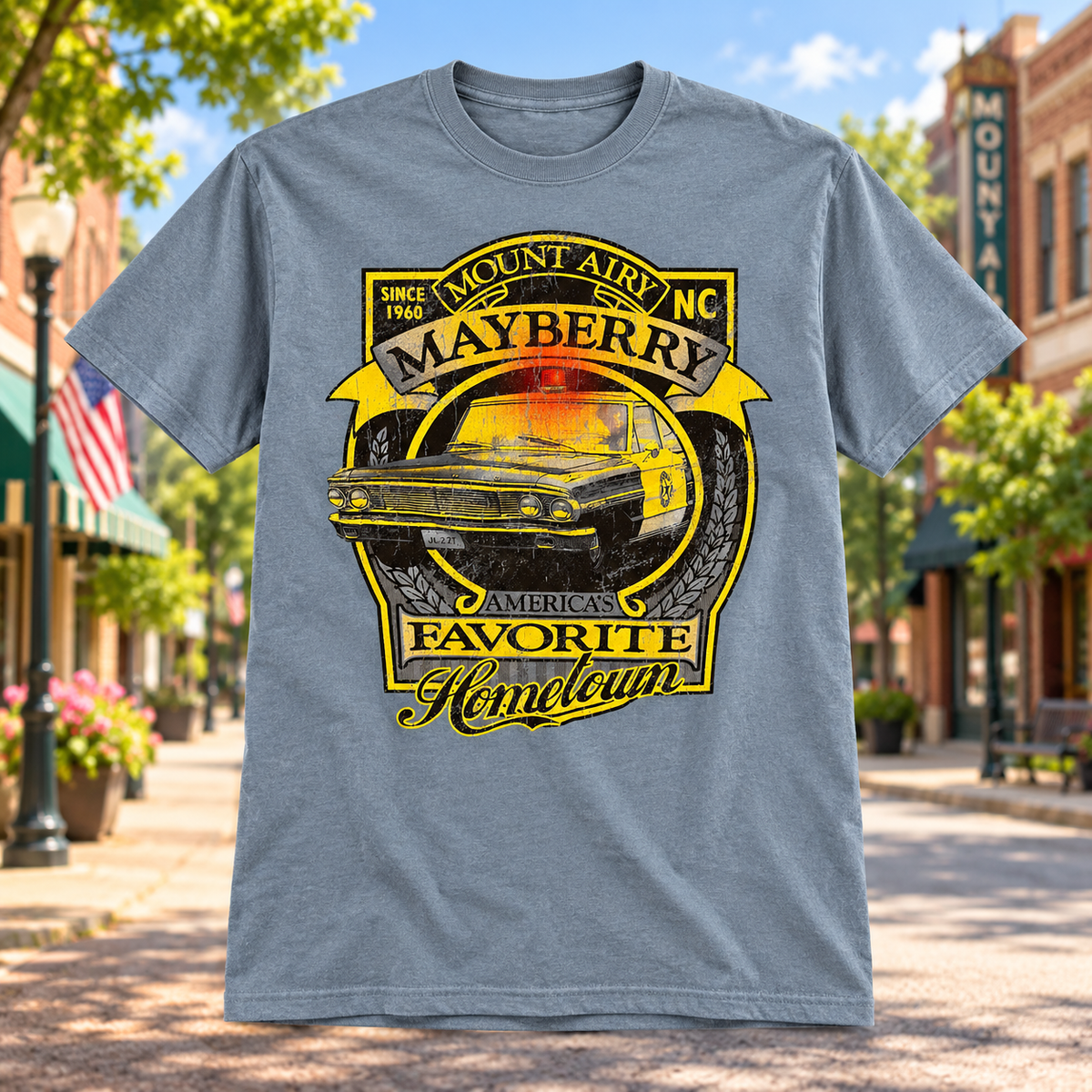 Mayberry America’s Favorite Hometown Squad Car T-Shirt in Heather Gray against a bright Mayberry Main Street background