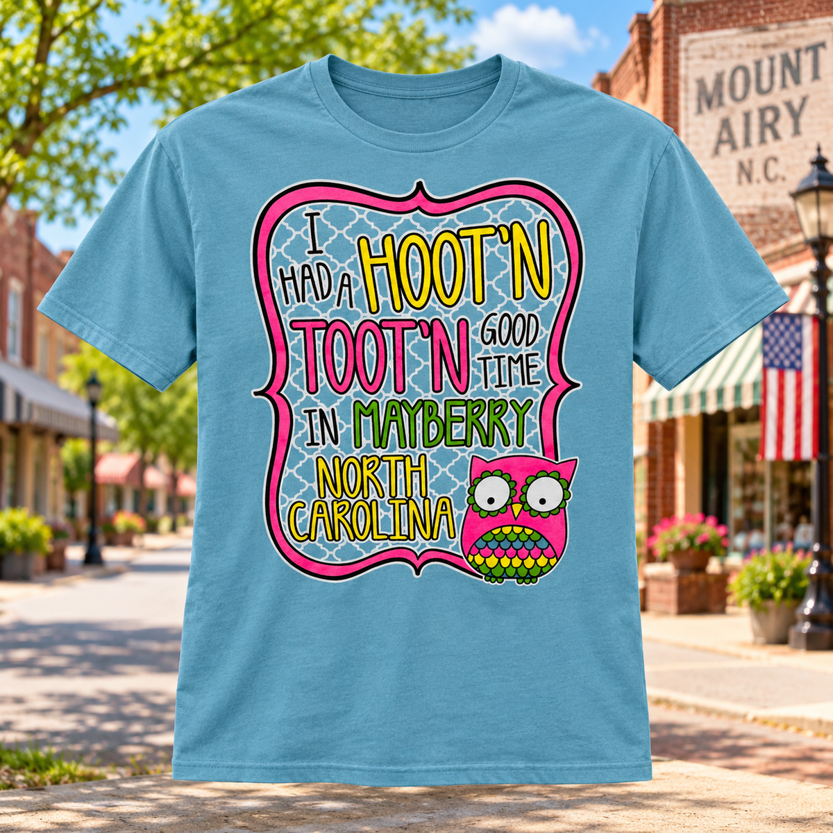 Hootin’ Tootin’ Good Time in Mayberry T-Shirt in Heather Blue against a bright Mayberry Main Street background