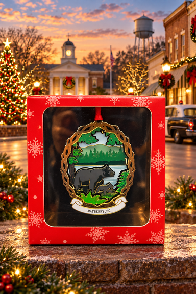 Black Bear and Cub Mayberry ornament in its red gift box against a festive Mayberry-themed backdrop