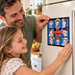 Father and daughter applying The Mayberry Bunch character sticker to a refrigerator.