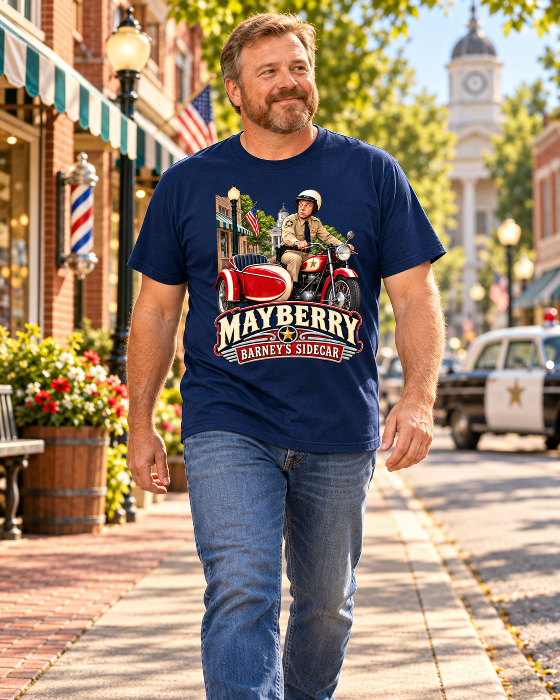 Man wearing Mayberry Barney's Sidecar T-Shirt – Navy walking on a Mayberry-inspired Main Street