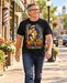 Man wearing Mayberry The Haunted House T-Shirt – Black walking on a Mayberry-inspired Main Street