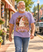 Man wearing Mayberry Mountain Wedding T-Shirt – Lavender walking on a Mayberry-inspired Main Street