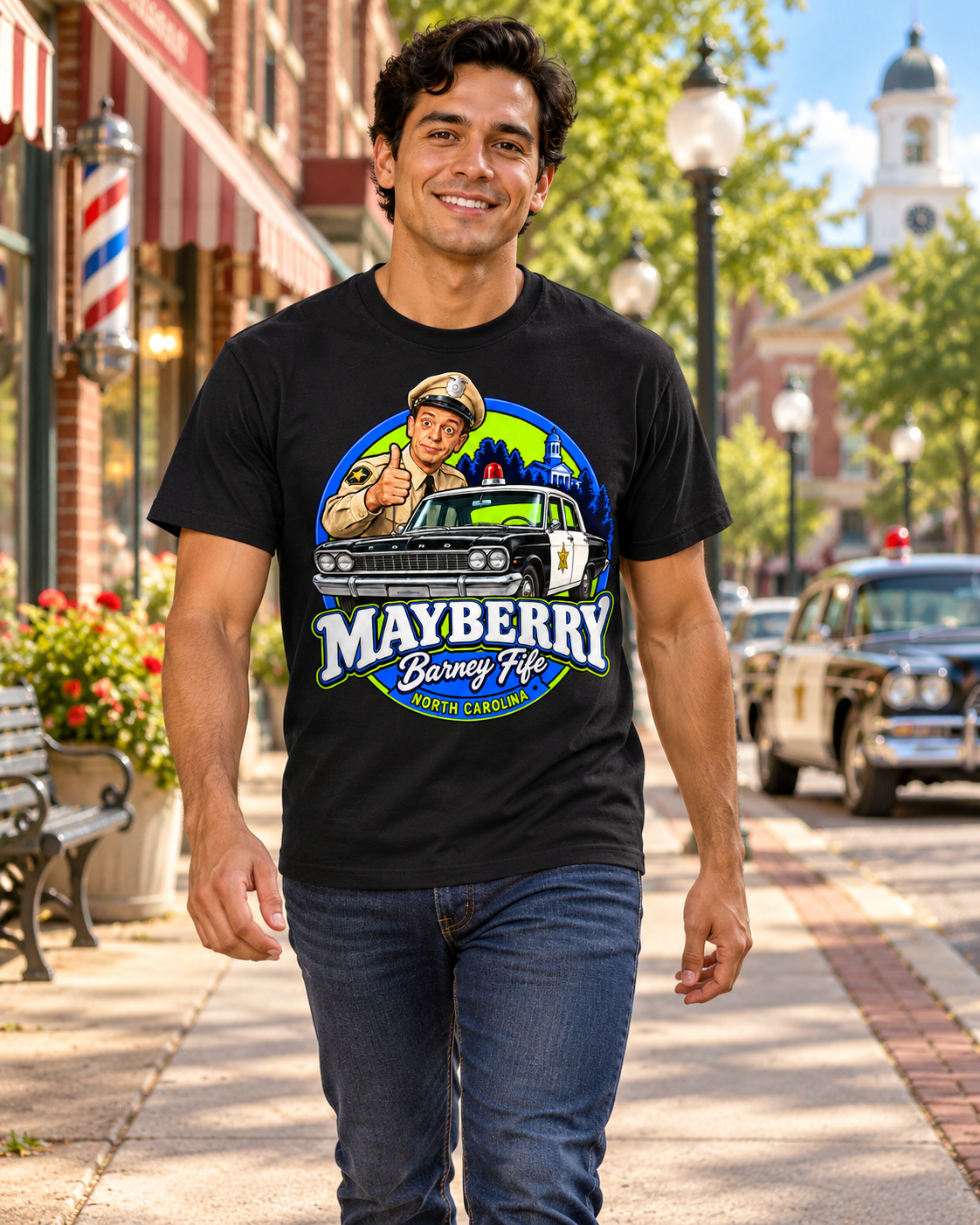 Man wearing Mayberry Barney Fife Squad Car T-Shirt – Black walking on a Mayberry-inspired Main Street