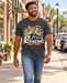 Man wearing Mayberry Double Trouble T-Shirt – Heather Charcoal walking on a Mayberry-inspired Main Street