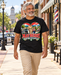 Man wearing Mayberry A Little Town with Heart T-Shirt – Black walking on a Mayberry-inspired Main Street