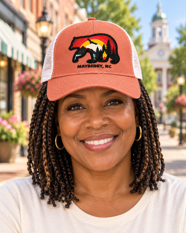 Model wearing Mayberry Mountain Bear Hat – Coral on a Mayberry-style downtown street
