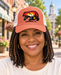 Model wearing Mayberry Mountain Bear Hat – Coral on a Mayberry-style downtown street