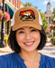 Model wearing Mayberry Mountain Bear Hat – Tan on a Mayberry-style downtown street