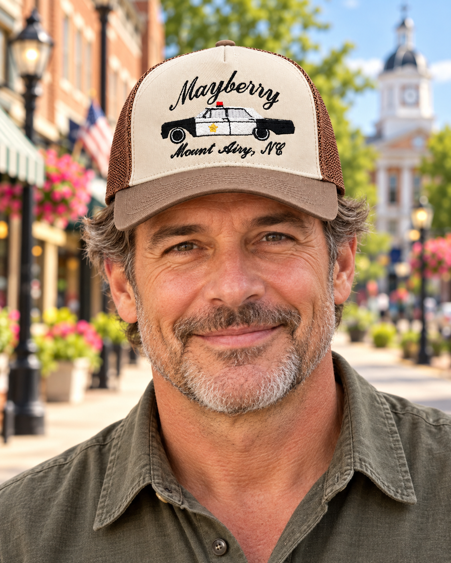 Model wearing Mayberry Squad Car Hat – Cream & Taupe on a Mayberry-style downtown street