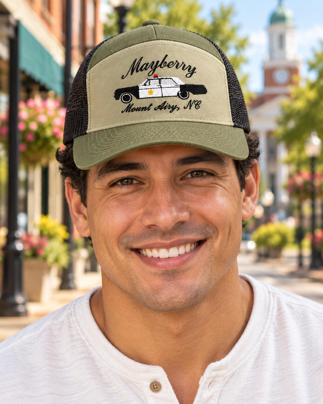 Model wearing Mayberry Squad Car Hat – Olive on a Mayberry-style downtown street