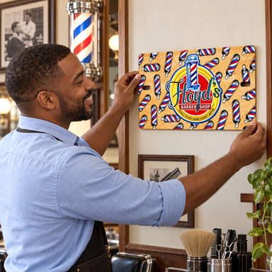 Man placing Mayberry Metal Sign - Floyd's Barber Shop on a wall