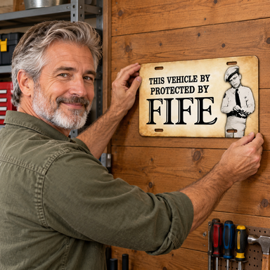 Man placing Mayberry Metal Sign - Protected by Fife on a wall