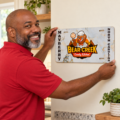 Man placing Mayberry Metal Sign - Bear Creek on a wall