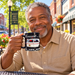 Model enjoying coffee with Mount Airy Real-Life Mayberry Squad Car Black Mug on Mayberry Main Street